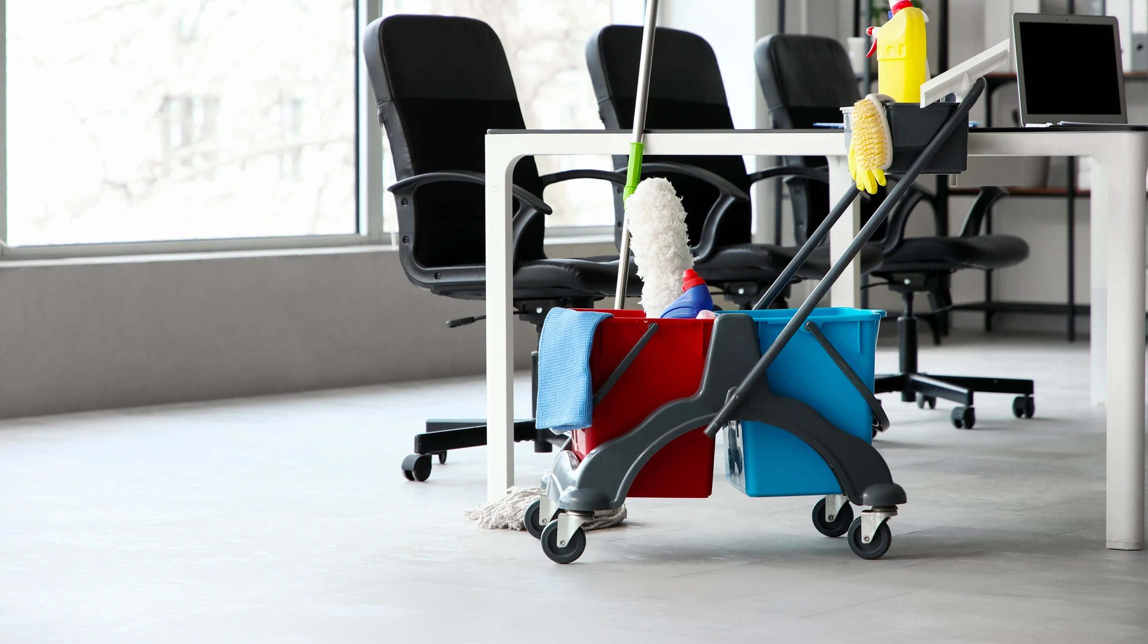 Scène intérieure d'un centre commercial avec chariot de nettoyage professionnel jaune positionné le long d'un mur